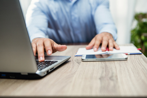 Man Uses Notebook, Phone and Laptop