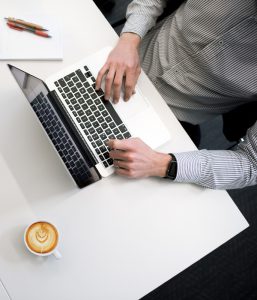 Person working on a computer with drink